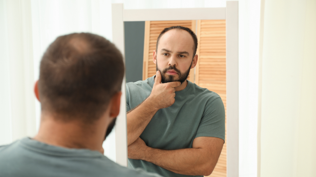 uomo che cerca di capire se ha testosterone alto o basso guardandosi allo specchio
